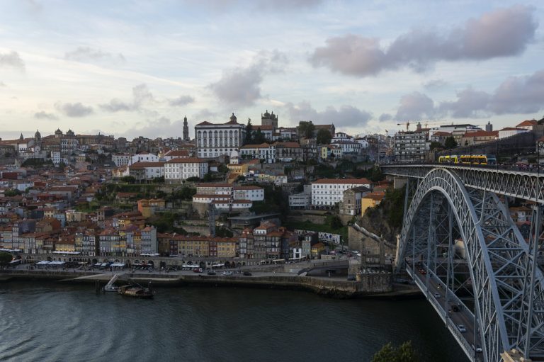 Beutiful Porto view, with Dom Luís Bridge and metro. Sunset, blue sky and clouds. Boats on the river.